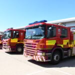 Fire engine in foreground with other vehicles in line