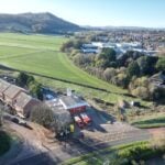 Fire engine and compact fire engine drone shot in front of fire station with countryside in background