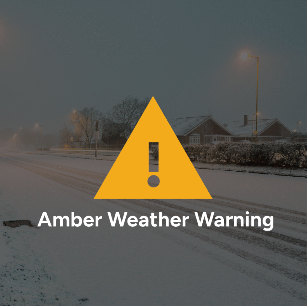 Amber weather warning symbol on a snowy background