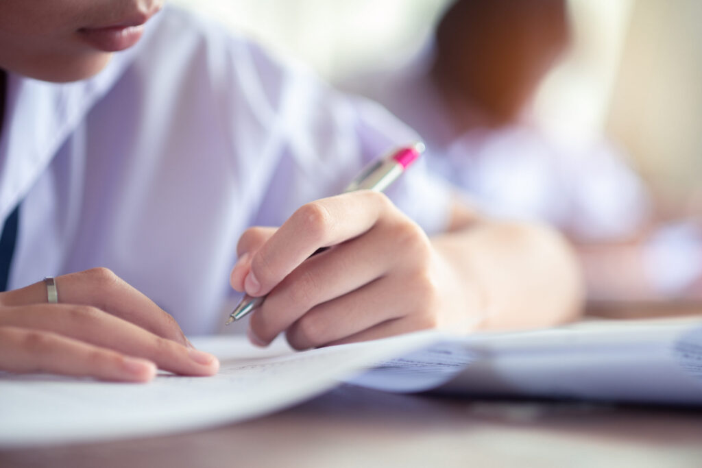 Person writing with a pen on paper