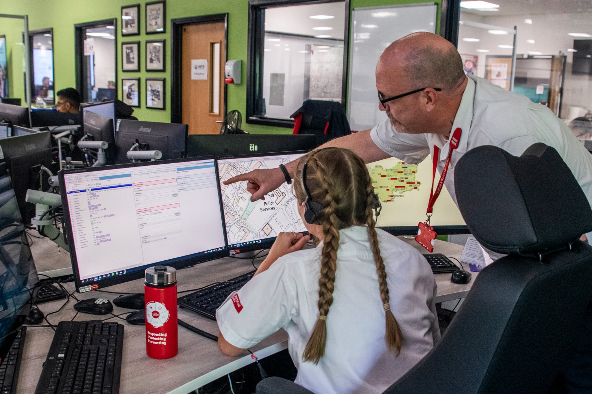 Two firefighter control operators looking at two computer screens