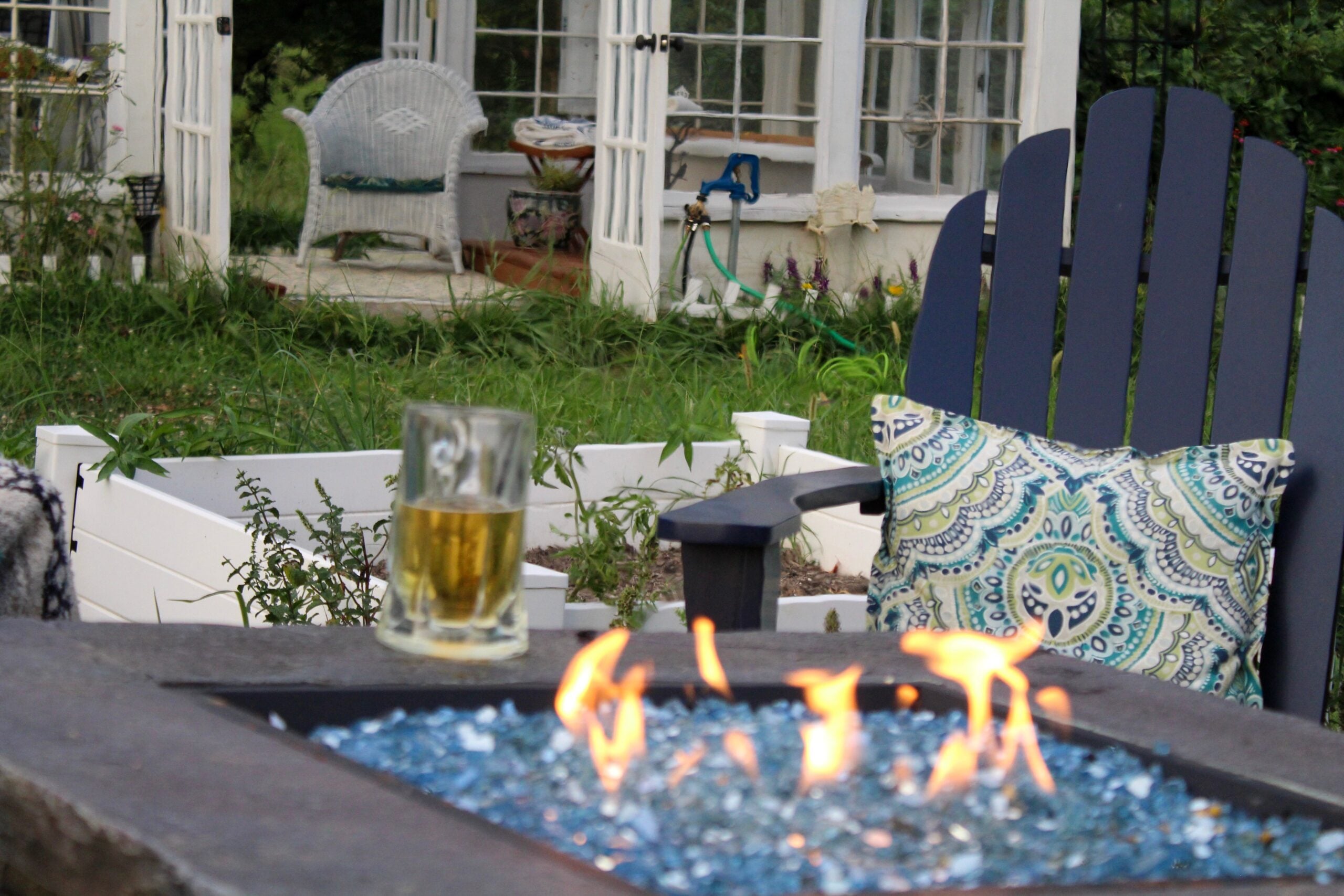 Lit fire pit with bioethanol fuel in a garden with chairs