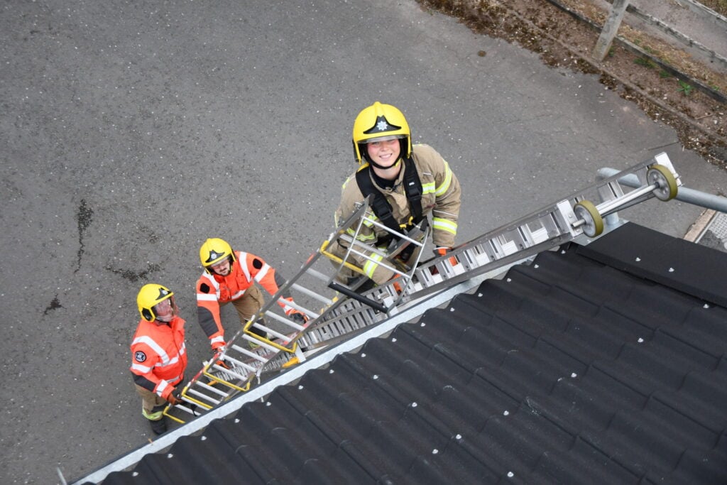 female firefighter on ladder at drill night